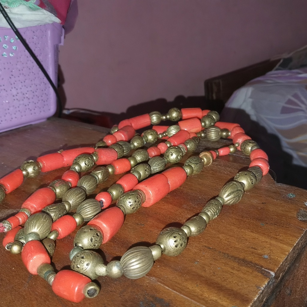 A beaded necklace, as a phone photo and as a finished studio frame